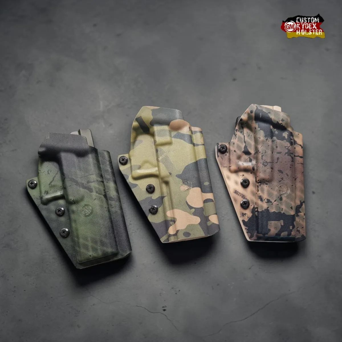 Drei Gear Maniacs GM ALPHA OWB Kydex Holster in den Designs Operator Boonies, Multicam Tropic und Operator Gunny – alle Modelle sind Optic Ready für Rotpunktvisiere.